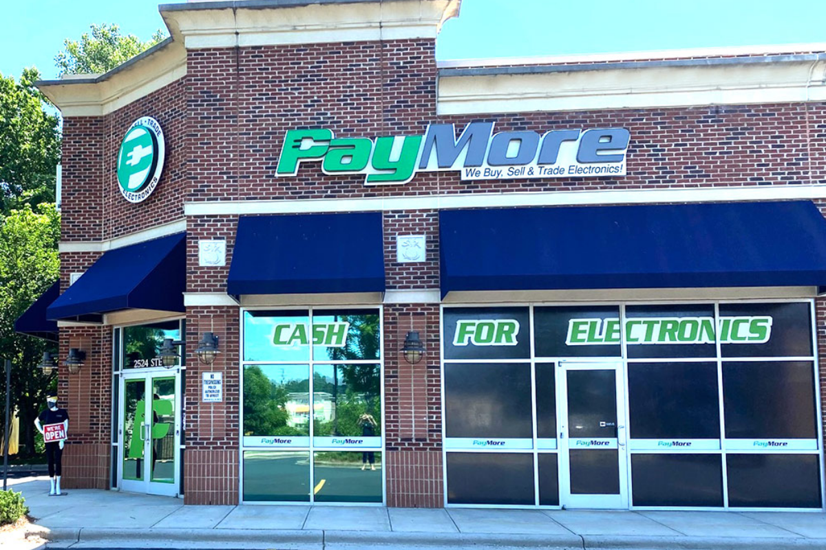 A brick building with a PayMore sign in green and blue