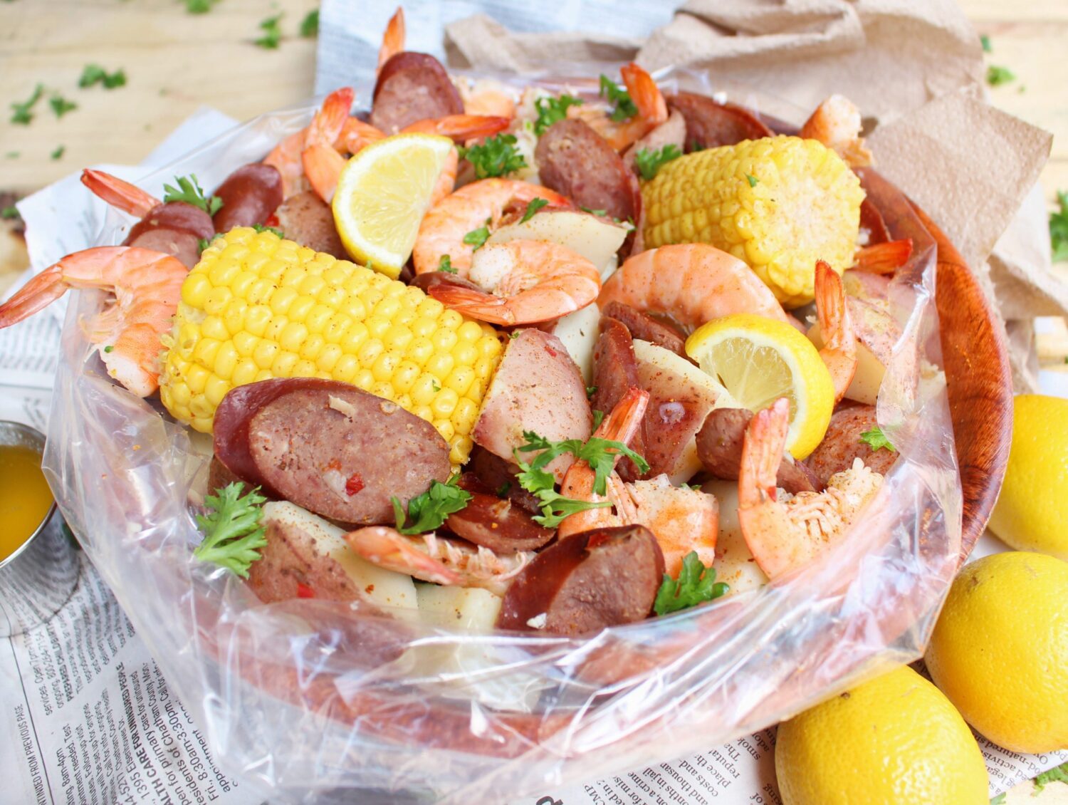 Seafood boil containing corn on the cob, sausage, shrimp and lemon