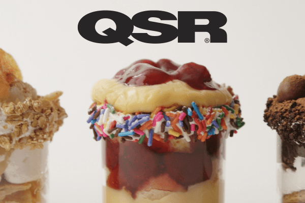 QSR in bold font above a tasty chocolate dessert loaded with colorful sprinkles