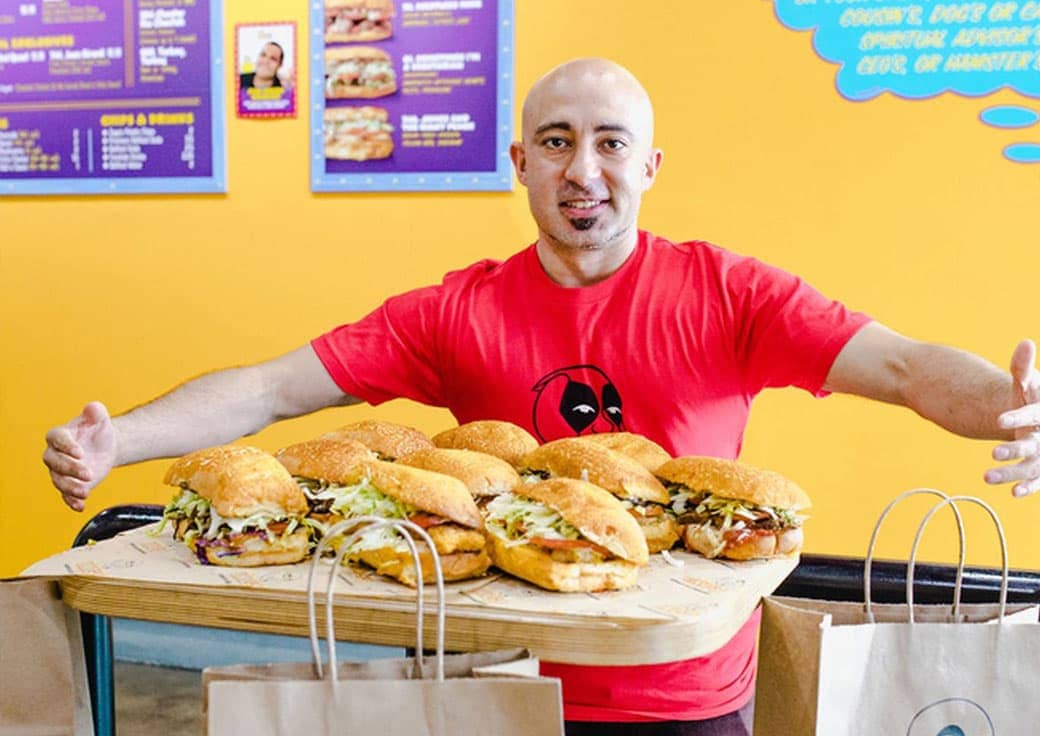 Ike standing in front of an image of various sandwiches