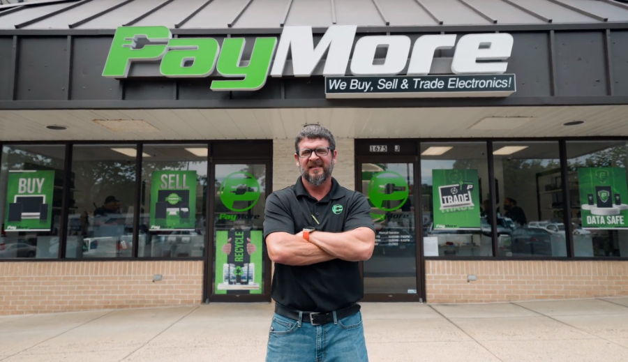 Dan Lowe Franchisee with arms crossed in front of PayMore store